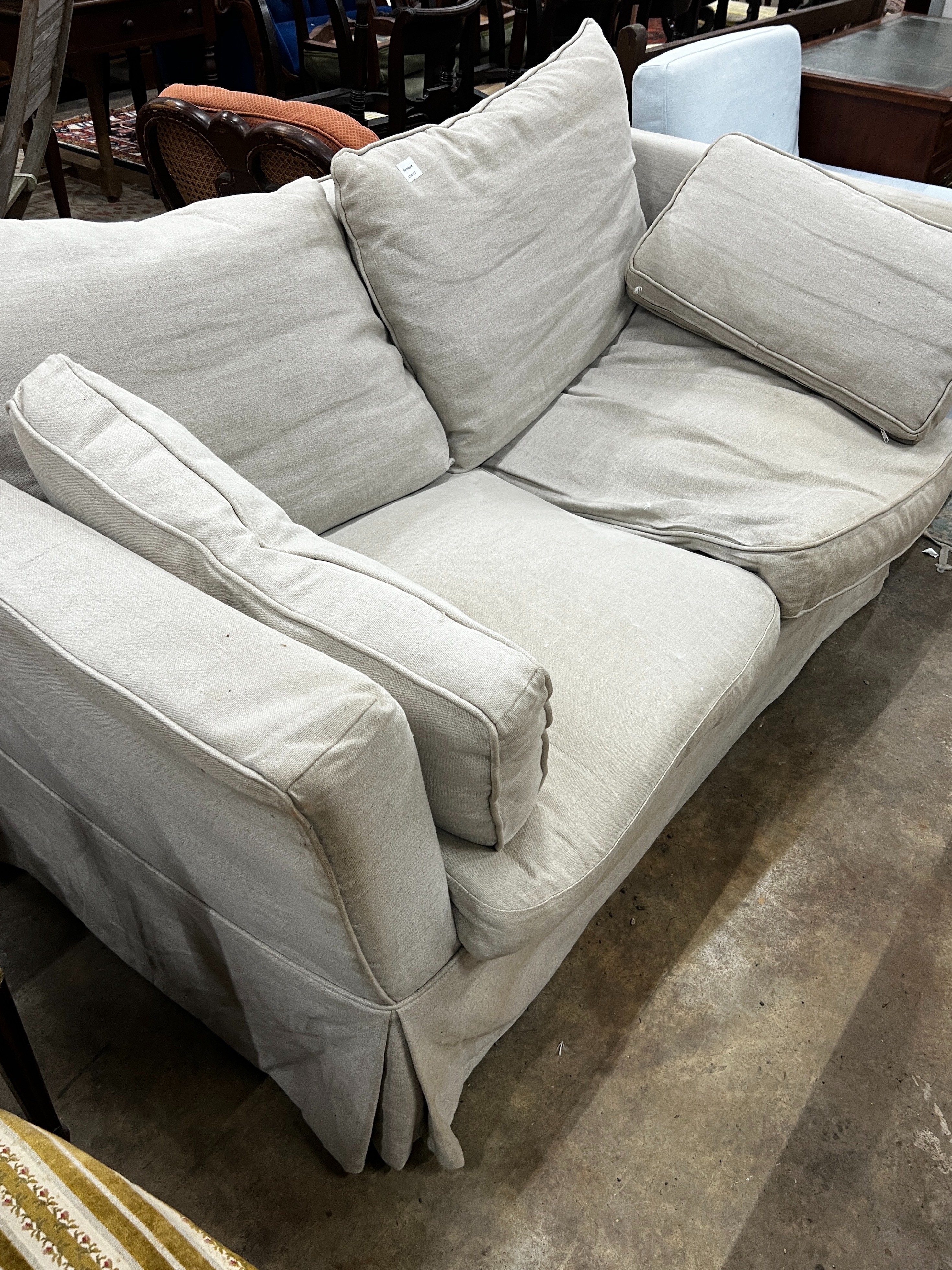 An Oka two seater settee upholstered in a natural linen fabric, length 1080, depth 98cm, height 80cm